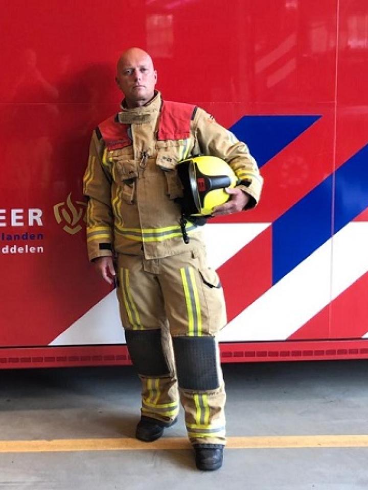 Brandweerman poseert voor dompelcontainer