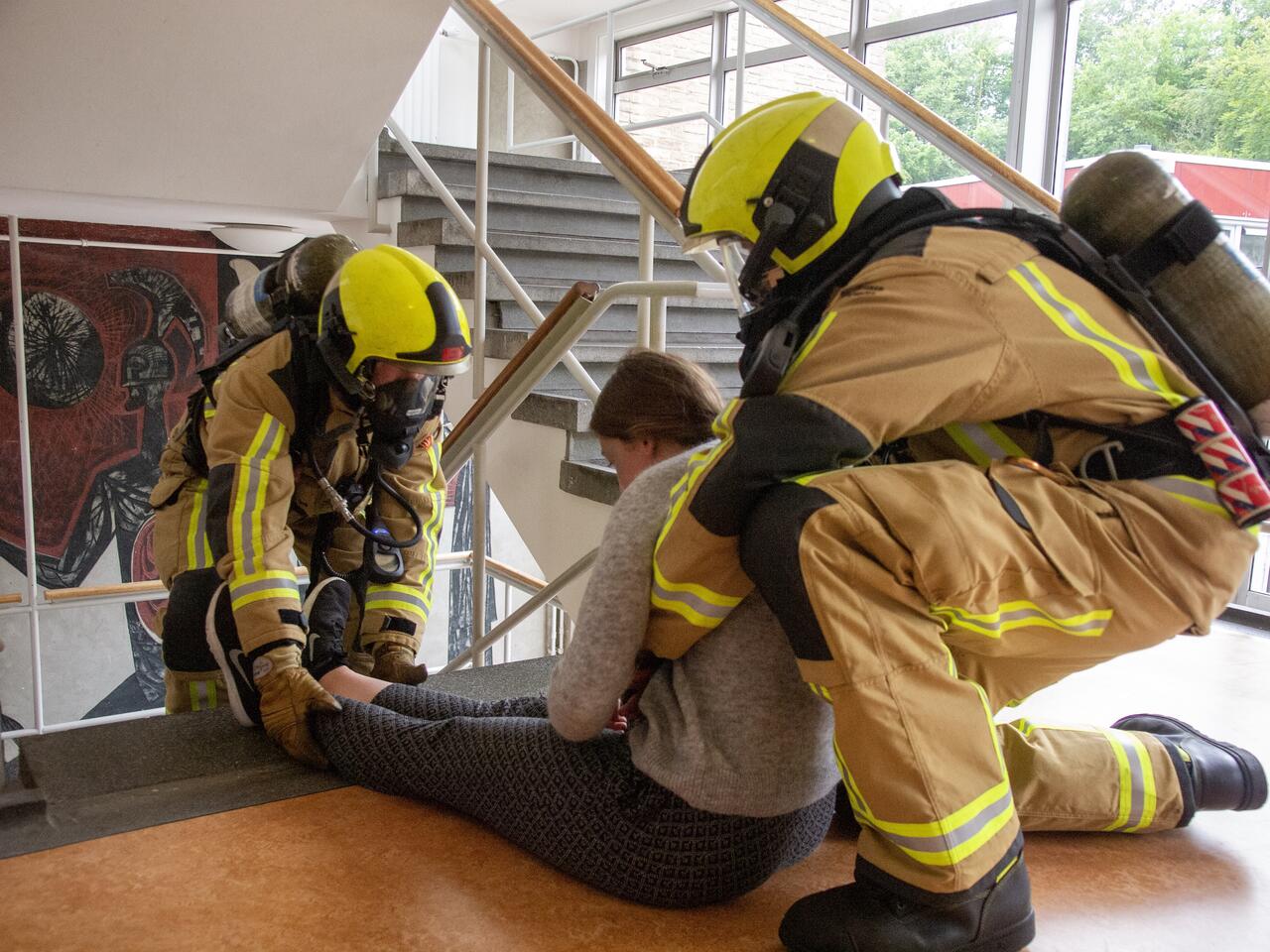 Brandweermensen oefening in trappenhuis