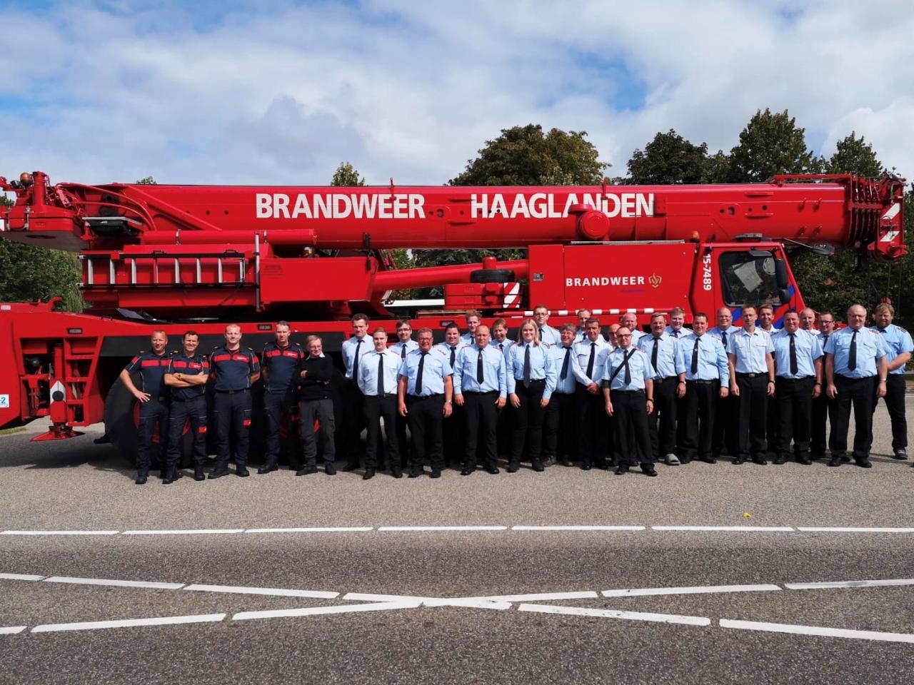 Duitse en Nederlandse brandweercollega's poseren voor brandweerwagen